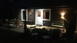 A small house with a porch, a table, and two chairs.