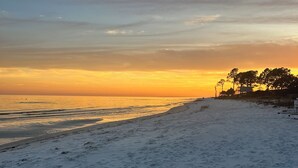 Uma praia com céu limpo e um pôr do sol.