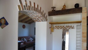 Une pièce avec un plafond en bois, un canapé, une table et un miroir surmonté d’une étagère en bois.