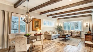 A spacious living room with wooden beams, a chandelier, a dining area with patterned chairs, and a sofa set. - Brand New 2 Bedroom Master Suites with Chefs Kitchen Steps to Sonoma Plaza (Sonoma)