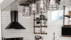 Une cuisine moderne avec un poêle noir, des armoires en bois et un plan de travail en marbre.