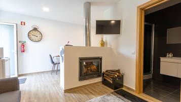 Una sala de estar moderna con chimenea, un reloj y un televisor de pantalla plana montado en la pared.