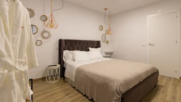 Ein Schlafzimmer mit einem großen Bett, einem Nachttisch, einer Hängelampe und einer Tür.