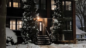 A two-story building with a snow-covered entrance and steps leading up to the door.