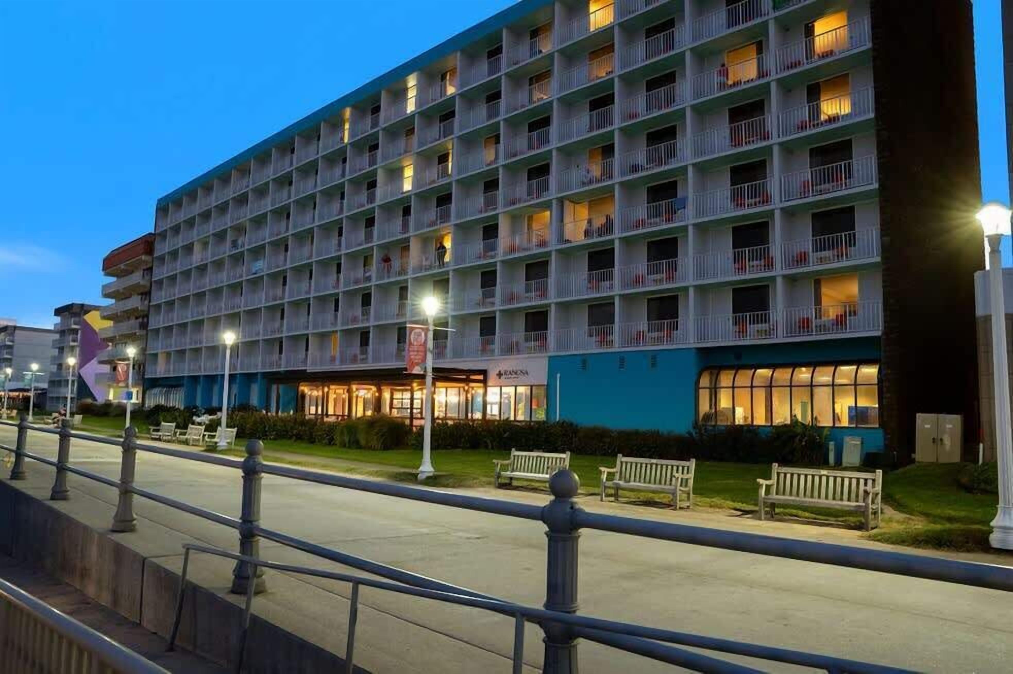 Ein mehrstöckiges Hotel mit Balkonen, einem sichtbaren Restaurant und einer gut beleuchteten Fassade.