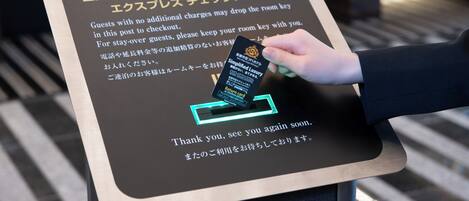 A sign with instructions for guests to drop off their room keys at the checkout area.