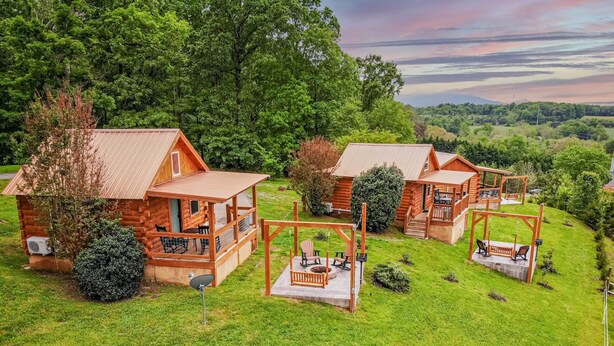 Een resort met blokhutten, met meerdere hutten, elk voorzien van een terras en een zitgedeelte buiten.