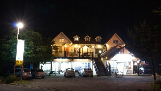A hotel with multiple levels, a covered outdoor area, and a parking lot. - Yangsan Park Pension (Yangsan)