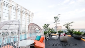 A rooftop terrace with seating areas, a pool, and a view of the city skyline. - Zenith Suites JBCC by OKGOSTAY (Johor Bahru)