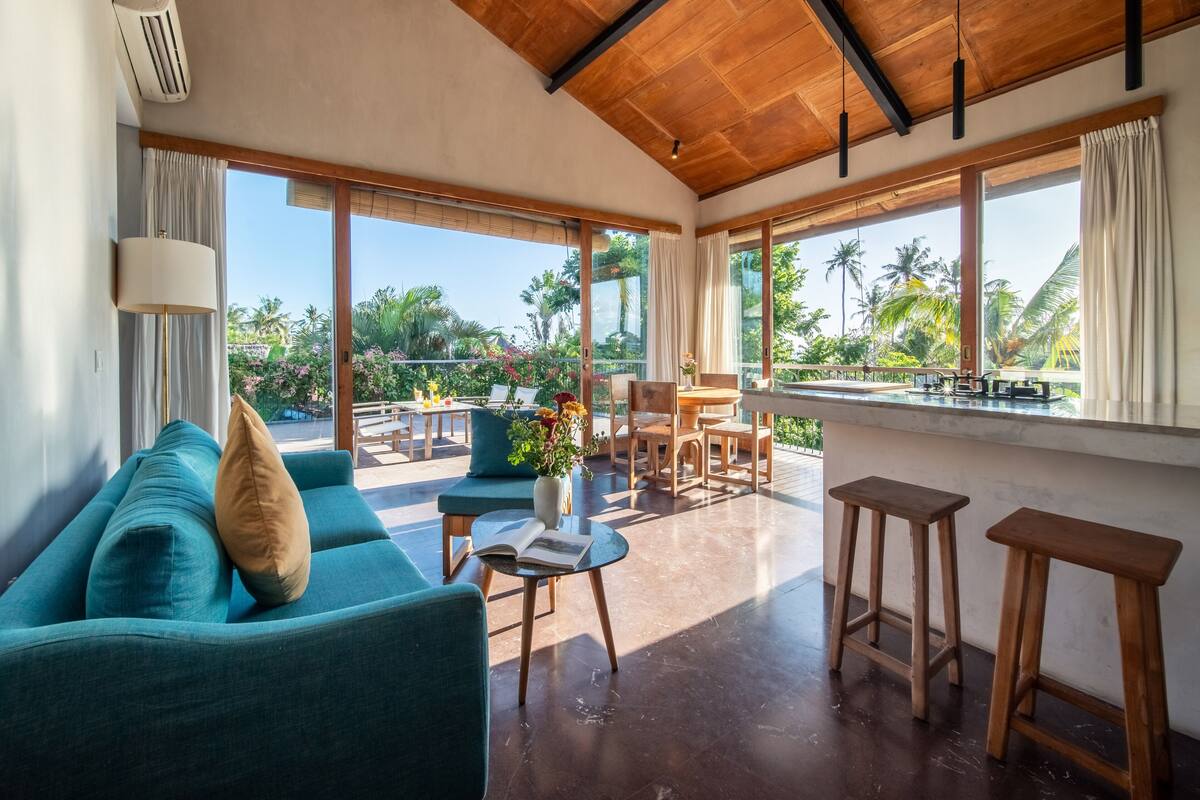 A spacious living area with a sofa, a coffee table, and a view of the outdoors.