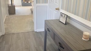 A hallway with a wooden bench, a sign indicating Wi-Fi, and a clock on the wall. - Super Nice townhouse in Virginia Beach (Virginia Beach)