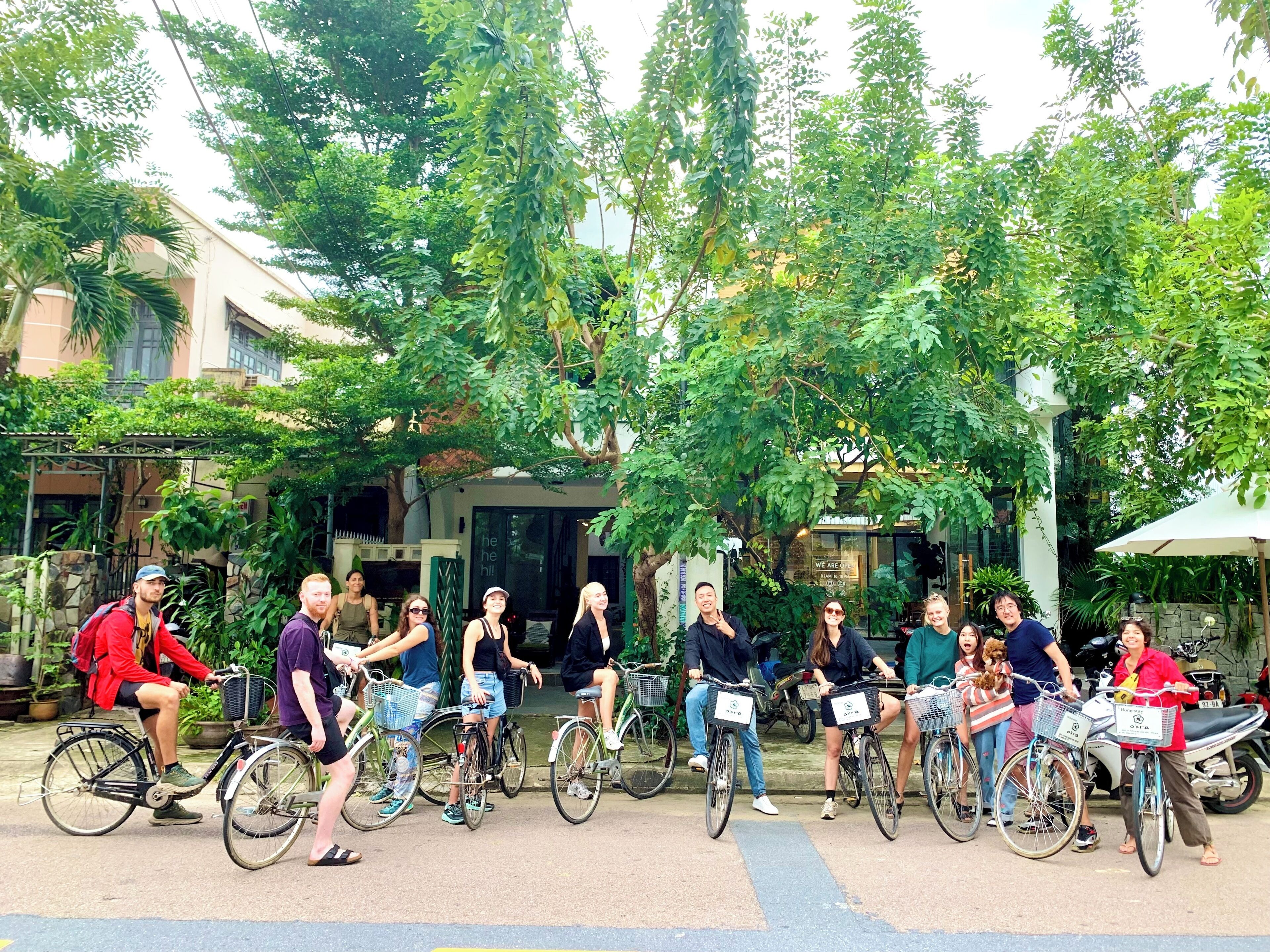 A group of people on bicycles in an outdoor setting with trees and a building in the background.