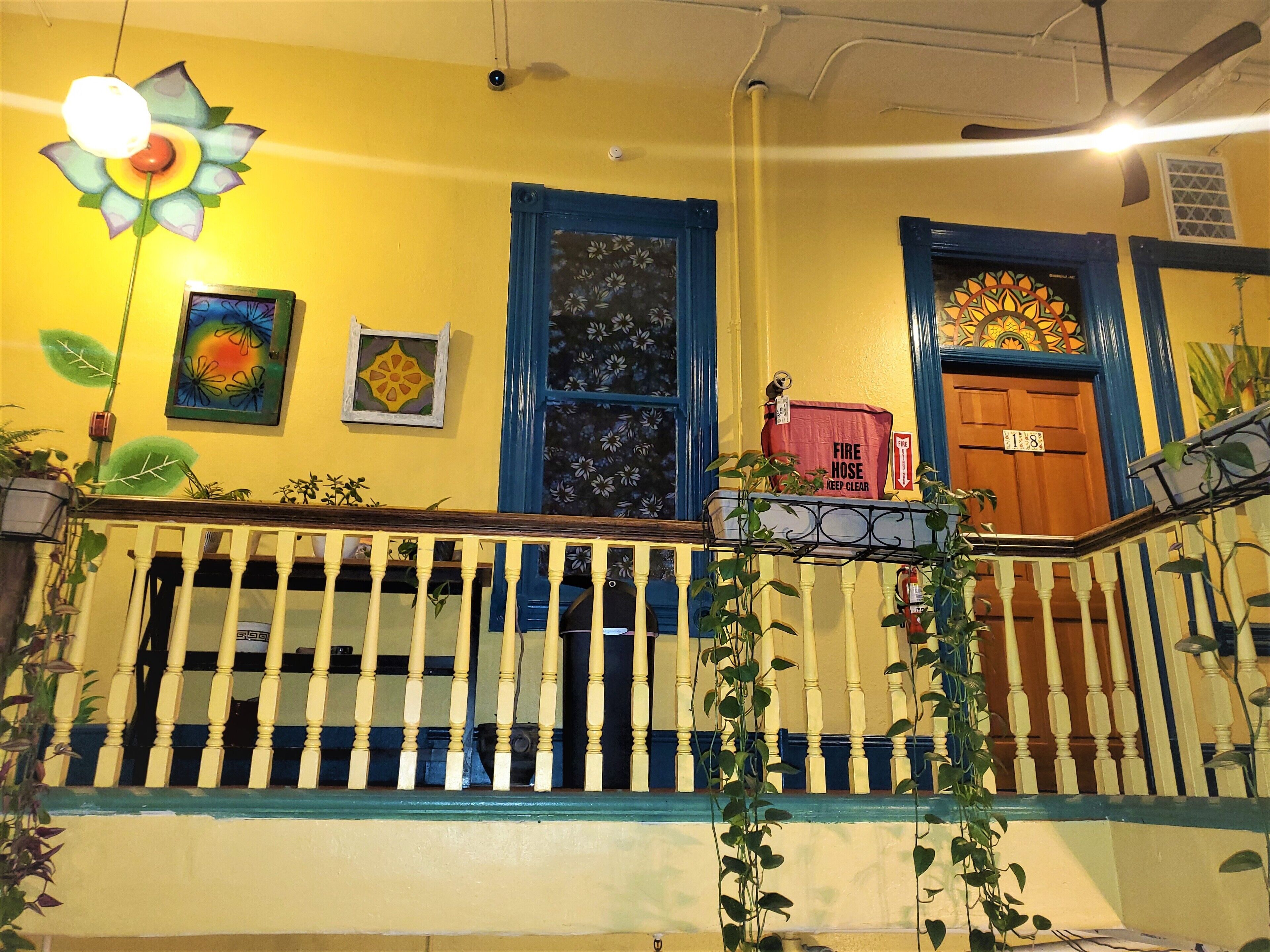 A yellow building with a blue door, a fire hose, and a fire hydrant.