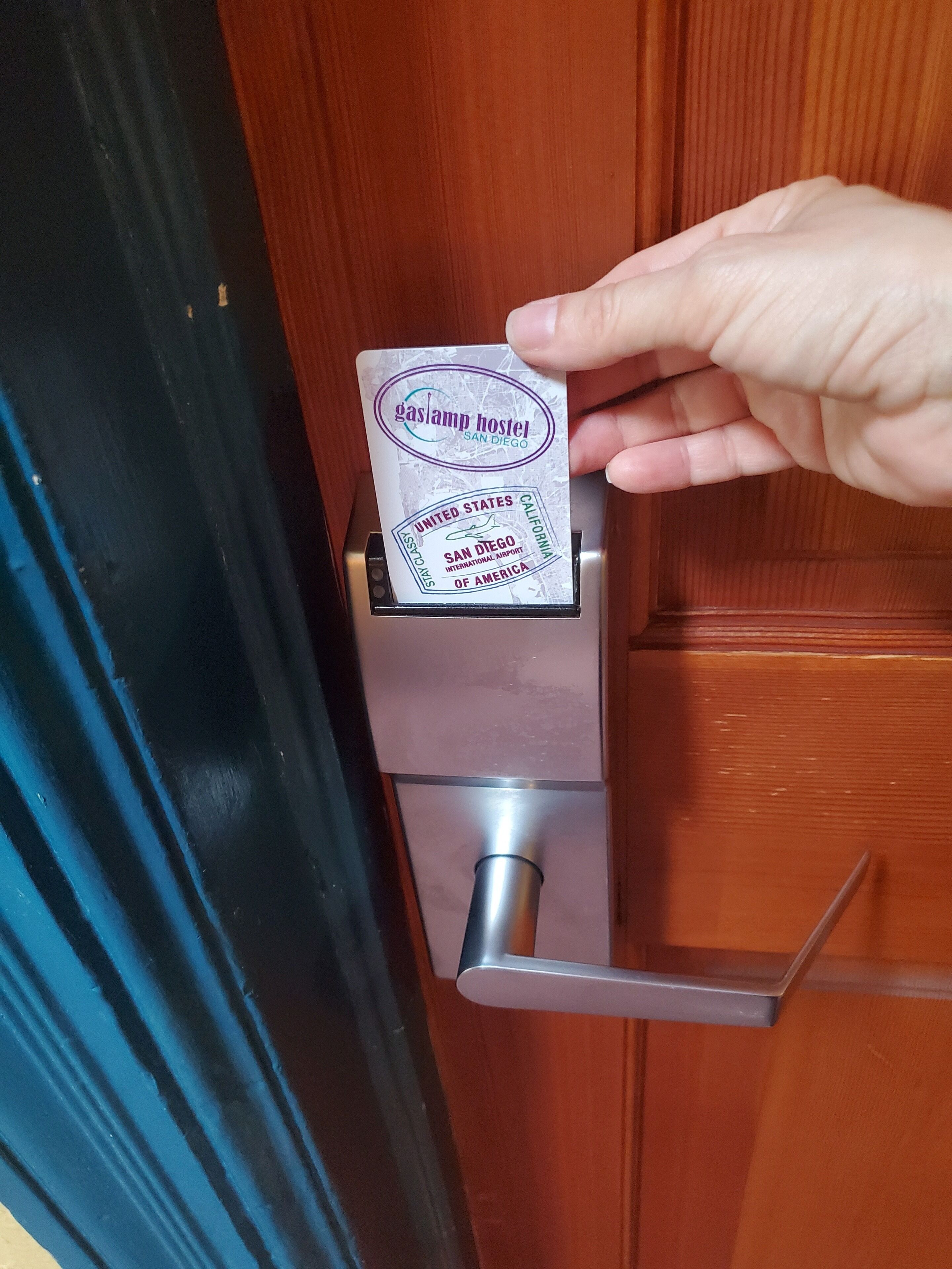 A hand inserting a key into a door lock.