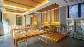 A restaurant with wooden tables and benches, a modern ceiling design, and a large window with a view. - Floral Hotel · Zai Yi Qi Lijiang (Lijiang)