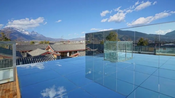 A rooftop terrace with a glass floor, offering a view of traditional buildings and mountains. - Floral Hotel · Zai Yi Qi Lijiang (Lijiang)
