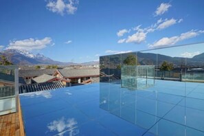 A rooftop terrace with a glass floor, offering a view of traditional buildings and mountains. - Floral Hotel · Zai Yi Qi Lijiang (Lijiang)