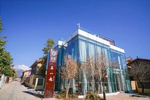 Un bâtiment moderne doté de grandes fenêtres en verre et d’une enseigne rouge avec du texte blanc.