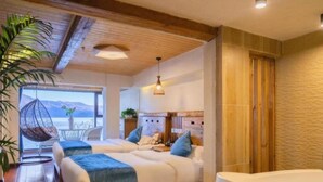 Un dormitorio con dos camas, una bañera grande y vistas a las montañas.