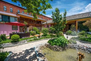A traditional building with a courtyard garden, including a pond and various plants.