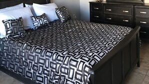 A bedroom with a large bed, a dresser, a mirror, and a framed picture on the wall. - Experience Casa Grande charm in our spacious 4-bedroom retreat (Casa Grande)
