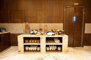 A marble counter with various kitchenware and a staff-only door. - Shourya Residency (Udaipur)