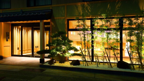 L’entrée d’un bâtiment est agrémentée d’un jardin japonais traditionnel, avec des rochers, du bambou et un sentier menant aux portes.