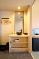 Un baño moderno con lavamanos, espejo y perchero.