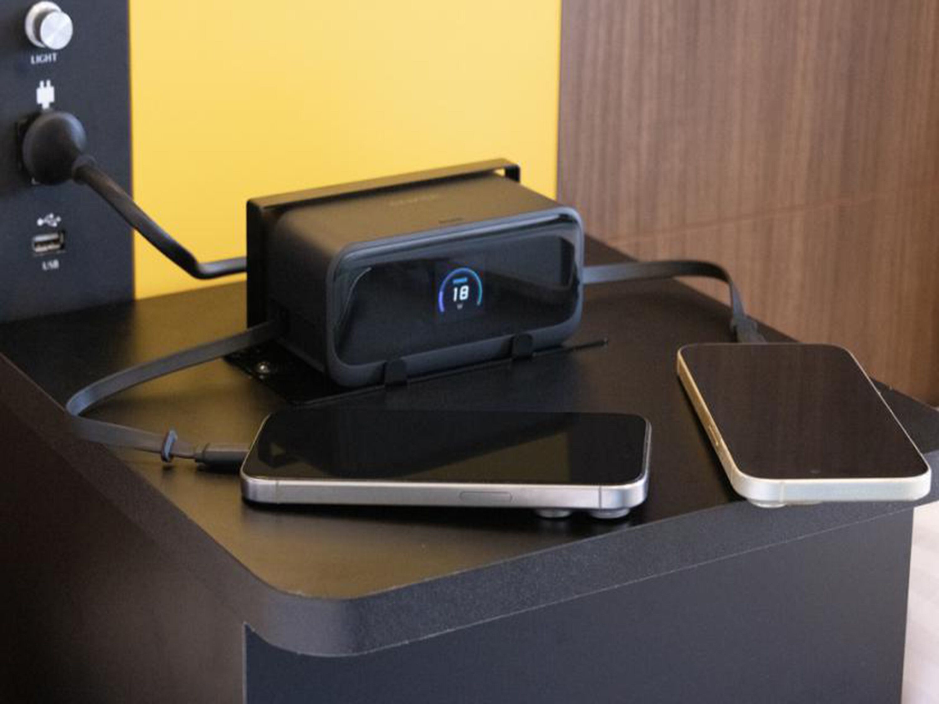 A charging station with two smartphones on a desk.