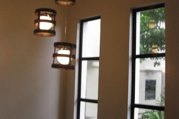 A room with large windows and hanging pendant lights. - Coron Paradise Bed & Breakfast (Coron)