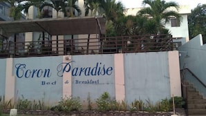 Un edificio con un letrero que dice "Coron Paradise Bed & Breakfast".