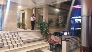 Een hotel lobby met een trap naar een receptie.
