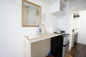 A compact kitchenette with a countertop, a kettle, a coffee maker, and a small refrigerator. - Hostel 758 Nagoya3A (Nagoya)