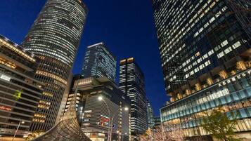 A modern urban skyline with high-rise buildings, including a distinctive curved structure in the foreground.