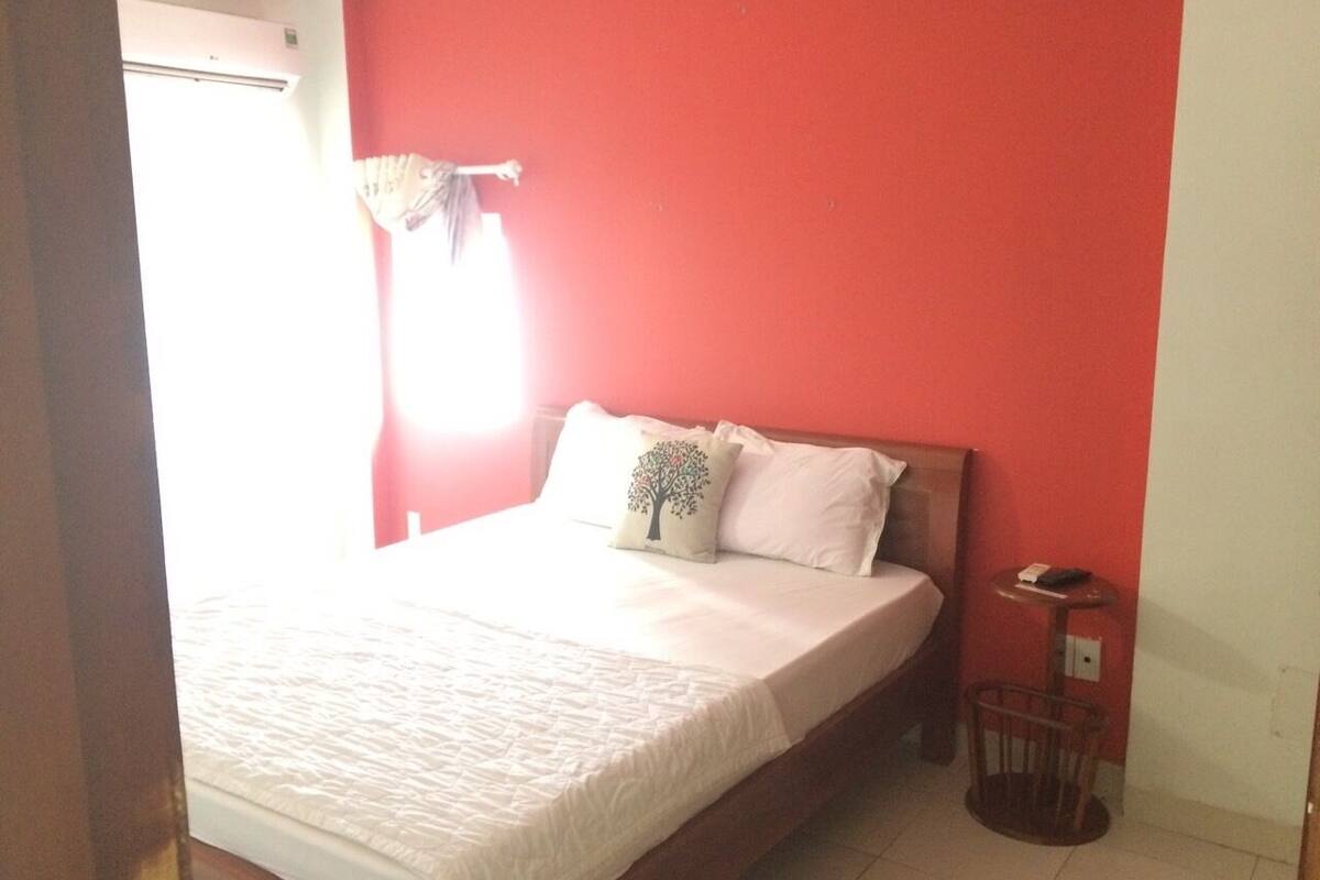 Un dormitorio con cama, mesita de noche y silla.