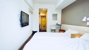 A hotel room with two beds, a desk, a chair, and a TV mounted on the wall. - Hostel 758 Nagoya3C (Nagoya)