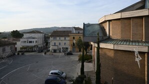 Una vista di strada con edifici, un parcheggio e cielo sereno.