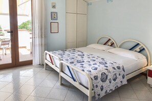 Un dormitorio con cama, armario y puerta que da a un espacio exterior.