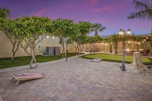 A courtyard with a paved patio, outdoor seating, and a fire feature.