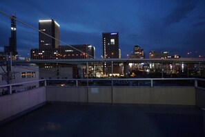 Un paisaje urbano nocturno con edificios modernos y un puente.