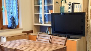 A wooden table and chairs, a television, a cabinet with glass doors, and books. - M244 - Marcelli, three-room apartment with terrace 150m from the sea (Marcelli)
