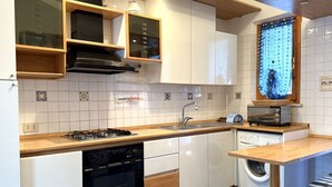 A compact kitchen with a gas stove, oven, dishwasher, and a built-in washing machine. - M244 - Marcelli, three-room apartment with terrace 150m from the sea (Marcelli)