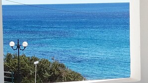 A view of the sea from a window, with a street lamp and greenery in the foreground. - Makrigialos: big family apartment, 2 bedrooms, sea views, WiFi (Makrigialos)