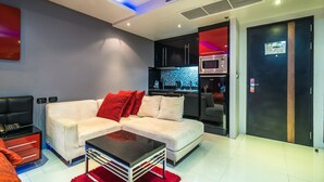 Una sala de estar moderna con un sofá, una mesa de centro y una cocina equipada.