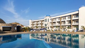 A resort with a large pool, multiple balconies, and a stone facade.