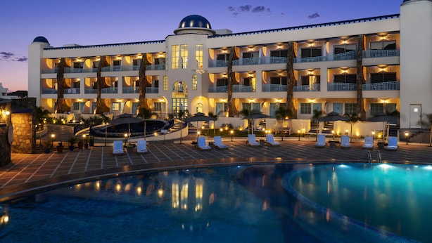 Ein Hotel mit großem Pool, mehreren Balkonen und einem zentralen Turm.