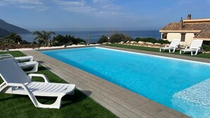 A swimming pool with lounge chairs, a wooden deck, and a view of the ocean. - Apt Mari E Monti A 2 Km Da Riserva Dello Zingaro (Castellammare del Golfo)