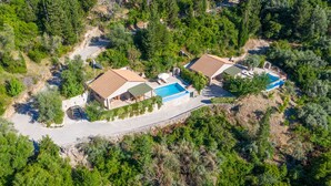 An aerial view of a property with two buildings, a swimming pool, and a driveway. - Kerithra Villa, overlooking Vasiliki bay, close to the beach and other amenities (Lefkada)