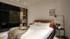 A modern bedroom with a large bed, a wardrobe, a bedside table with a lamp, and a wall-mounted clock. - Single Eyelid Hostel (Yuanshan)