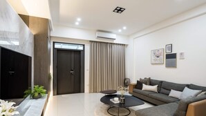 A modern living room with a sofa, coffee table, and artwork on the wall. - Single Eyelid Hostel (Yuanshan)